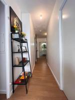 a hallway with a black book shelf in a house at SSP Suites- Cosy &amp; Bel appartement 4 pièces 3 chambres 90M2 avec balcon in Épinay-sur-Seine