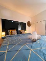 a bedroom with a large bed with a blue blanket at SSP Suites- Cosy &amp; Bel appartement 4 pièces 3 chambres 90M2 avec balcon in Épinay-sur-Seine