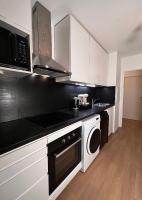 a kitchen with white cabinets and a stove top oven at SSP Suites- Cosy &amp; Bel appartement 4 pièces 3 chambres 90M2 avec balcon in Épinay-sur-Seine