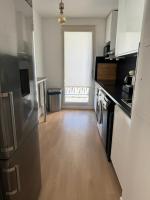 a kitchen with a refrigerator and a wooden floor at SSP Suites- Cosy &amp; Bel appartement 4 pièces 3 chambres 90M2 avec balcon in Épinay-sur-Seine