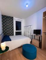 a bedroom with a large bed and a blue stool at SSP Suites- Cosy &amp; Bel appartement 4 pièces 3 chambres 90M2 avec balcon in Épinay-sur-Seine