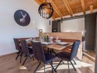 a dining room with a wooden table and chairs at Grebenzen Lodge Prinz in Sankt Lambrecht
