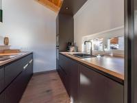 a kitchen with black cabinets and a counter top at Grebenzen Lodge Prinz in Sankt Lambrecht