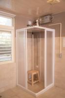 a white shower with a stool in a bathroom at Guanziling Lin Kuei Yuan Hot Spring Resort in Baihe