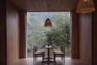 una sala da pranzo con tavolo e sedie e una grande finestra di SHANAN·深溪 ad Anji