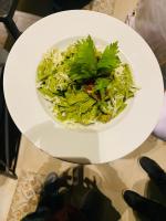 un plato blanco con una ensalada en una mesa en The Shanti A Boutique Hotel, en Jodhpur