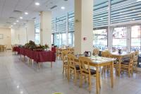 ein Esszimmer mit Tischen, Stühlen und Fenstern in der Unterkunft Grand Hotel Nirvana - All Inclusive & Free Beach Access in Sonnenstrand