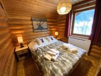 a bedroom with a bed in a log cabin at LE GRAND CERF Chalet en rondins avec SPA Jacuzzi in La Bresse