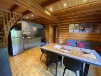 a kitchen and dining room with a table and chairs at LE GRAND CERF Chalet en rondins avec SPA Jacuzzi in La Bresse