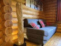 a blue couch in a room with wooden walls at LE GRAND CERF Chalet en rondins avec SPA Jacuzzi in La Bresse