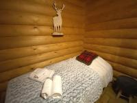 a bedroom with a bed in a log cabin at LE GRAND CERF Chalet en rondins avec SPA Jacuzzi in La Bresse