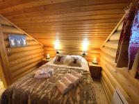 a bedroom with a bed in a wooden cabin at LE GRAND CERF Chalet en rondins avec SPA Jacuzzi in La Bresse