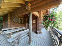 a porch of a log cabin with flowers at LE GRAND CERF Chalet en rondins avec SPA Jacuzzi in La Bresse