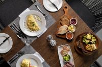 Una mesa de madera con platos de comida encima. en Leopard Sands Kruger Park, en Skukuza