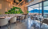 a restaurant with tables and chairs and large windows at Seehotel zur Post in Tegernsee