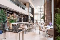 バンコクにあるRamada Plaza by Wyndham Bangkok Sukhumvit 48のテーブルと椅子と植物のあるレストラン