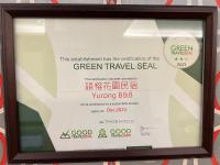 a framed sign in a window of a green travel deal at Yurong B&amp;B in Magong