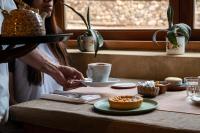 a woman is holding a cup of coffee on a table at Villa del Cielo in Tilcara