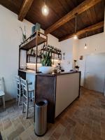 a kitchen with a counter and a bar with chairs at B&B Terra di Marca in Montefortino