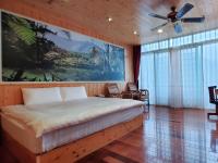 a bedroom with a bed and a large painting on the wall at Kingtaiwan Hotel in Lugu Lake