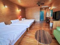 a room with a row of beds and a table at Kingtaiwan Hotel in Lugu Lake