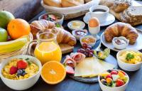 a table with a bunch of breakfast foods and drinks at Skiathos Holiday Resort in Skiathos