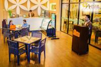 um grupo de pessoas sentadas às mesas de um restaurante em Aziza Paradise Hotel em Puerto Princesa