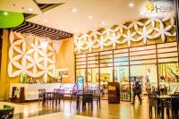 uma pessoa a caminhar através de um restaurante com mesas e cadeiras em Aziza Paradise Hotel em Puerto Princesa