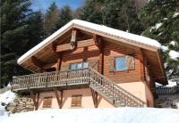 a log cabin with a balcony in the snow at LE GRAND CERF Chalet en rondins avec SPA Jacuzzi in La Bresse