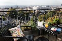 a balcony with two benches and a table with a view at Terrass&quot; Hotel in Paris