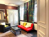 a living room with a red couch and two chairs at La Domus Lemaitre 1, plain-pied, Wifi , TV, parking, jardin 