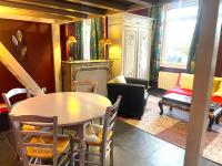 a dining room with a table and chairs and a living room at La Domus Lemaitre 1, plain-pied, Wifi , TV, parking, jardin 