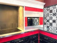 a kitchen with red walls and a large mirror at La Domus Lemaitre 1, plain-pied, Wifi , TV, parking, jardin 
