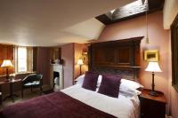 a bedroom with a large bed with purple pillows at The Rookery in London