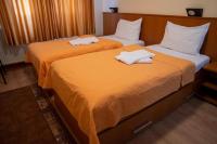 two beds in a hotel room with towels on them at Hotel Pepa in Divčibare