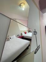 two beds in a room with a mirror at 萩閣民宿Sara&#39;s House走路可到夜市近市區好停車 in Hualien City