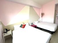 two beds in a room with pink walls at 萩閣民宿Sara&#39;s House走路可到夜市近市區好停車 in Hualien City