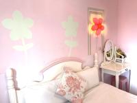 a bedroom with a white bed with flowers on the wall at 萩閣民宿Sara&#39;s House走路可到夜市近市區好停車 in Hualien City