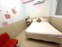 a bedroom with a bed and a red chair at 萩閣民宿Sara&#39;s House走路可到夜市近市區好停車 in Hualien City
