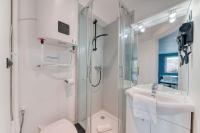 ein weißes Bad mit einer Dusche und einem Waschbecken in der Unterkunft Atelier-Gerland in Lyon