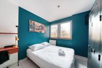 ein blaues Schlafzimmer mit einem Bett und einem TV in der Unterkunft Atelier-Gerland in Lyon