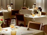 a restaurant with white tables and chairs with wine glasses at Il Cardello Locanda in Casola Valsenio
