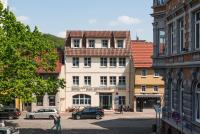 a city street with cars parked in front of a building at B&amp;S Hotel Am Bachhaus in Eisenach
