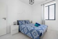 a bedroom with a bed with a blue comforter and a window at Maison avec jardin &quot;les Néréïdes&quot; port et plage de la Pointe Rouge Marseille in Marseille