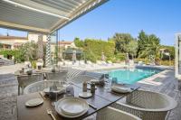 - une table à manger et des chaises à côté de la piscine dans l'établissement Casa Dina, à Sommières