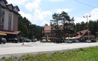 a street in a town with cars parked on the street at Hotel Pepa in Divčibare