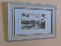 a framed picture of cattle and palm trees on a wall at Chambre diamants in Saint-Pierre