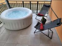 a large bath tub sitting on a balcony with a chair at Les Gîtes du Manguier in Anse-Bertrand