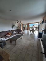 a living room with a couch and a table at Chalet avec vue panoramique sur les Montagnes du Mole et la chaîne des Aravis piscine chauffée à 5 min des pistes de la station des Brasses in Viuz-en-Sallaz