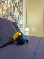 a stuffed bird is sitting on a bed at Le Toucan Tropical, F2 bis emplacement central in Fort-de-France